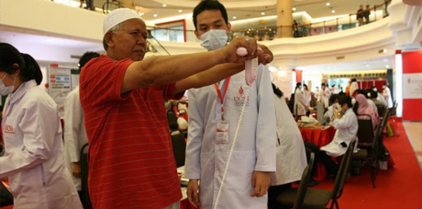 A student from UCSI University's Pharmacy Student Association (UCSIUPSA) from the Faculty of Pharmaceutical Sciences attending to a patient during the 10th Annual Public Health Campaign 2011 held in Kuantan