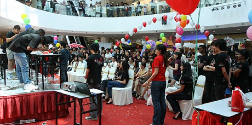 Crowds watch the watermelon​-eating contest during the UCSI University WOW Food Fair 2011 at Empire Shopping Gallery in Subang Jaya.